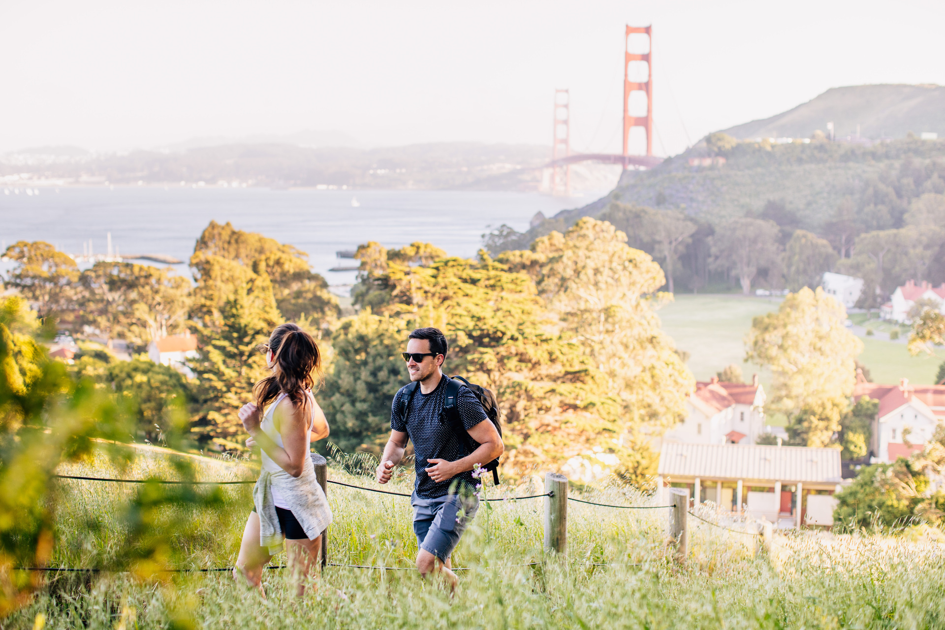 couple hiking golden gate and property in background